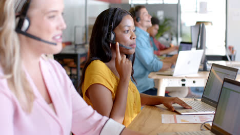 Happy-african-american-casual-businesswoman-and-diverse-colleagues-using-phone-headsets,-slow-motion
