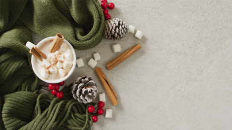 Video-of-cup-of-hot-chocolate-with-marshmallows-and-warm-blanket-over-grey-background