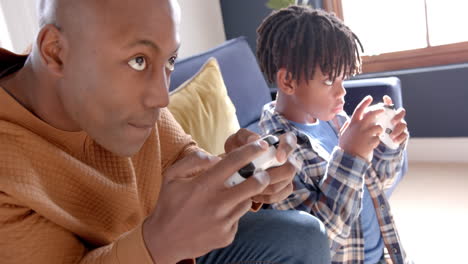 African-american-father-and-son-playing-video-games-at-home,-slow-motion