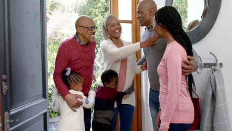 Happy-african-american-parents,-son-and-daughter-welcoming-visiting-grandparents,-slow-motion
