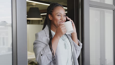 Fröhliche-Afroamerikanische-Geschäftsfrau,-Die-Telefoniert-Und-Kaffee-Trinkt,-Zeitlupe