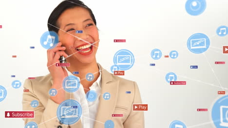 Animation-of-digital,-social-media-icons-over-biracial-businesswoman-talking-on-smartphone-at-office