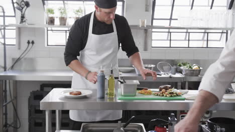Group-of-diverse-male-chefs-preparing-meals-in-kitchen,-slow-motion