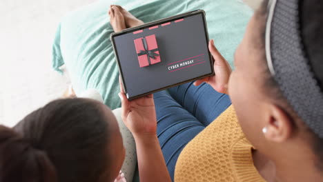 African-american-mother-and-daughter-using-tablet,-shopping-online-on-cyber-monday,-slow-motion