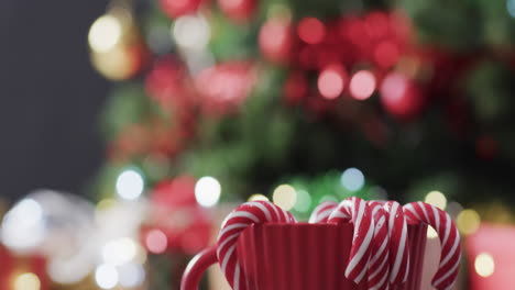 Video-of-red-mug-with-christmas-cnady-canes-and-christmas-tree-lights-with-copy-space