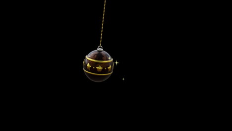 Swinging-black-and-gold-christmas-bauble-and-gold-sparkles-on-black-background