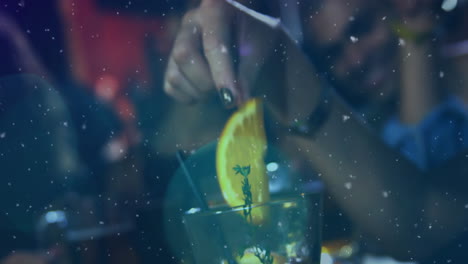 Animation-of-spots-of-light-against-mid-section-of-woman-putting-orange-slice-of-in-drink-at-a-bar