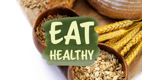 Animation-of-eat-healthy-text-banner-against-close-up-of-variety-of-bread-and-grains
