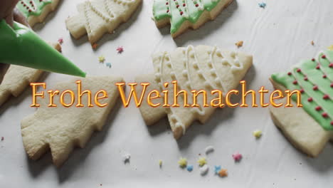 Frohe-weihnachten-text-in-orange-over-decorated-christmas-cookies-on-white-background