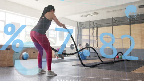 Animation-of-interface-processing-data-over-caucasian-woman-cross-training-with-battle-ropes-at-gym
