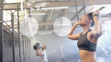 Animation-of-data-on-interface-over-african-american-woman-cross-training-with-medicine-ball-at-gym