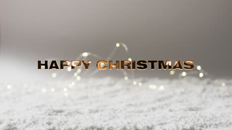 Texto-Feliz-Navidad-En-Oro-Sobre-Nieve-Y-Luces-De-Cadena-Y-Fondo-Gris