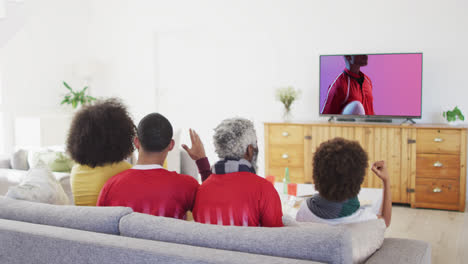 Biracial-Familie-Vor-Dem-Fernseher-Mit-Afroamerikanischem-Rugbyspieler-Mit-Ball-Auf-Dem-Bildschirm