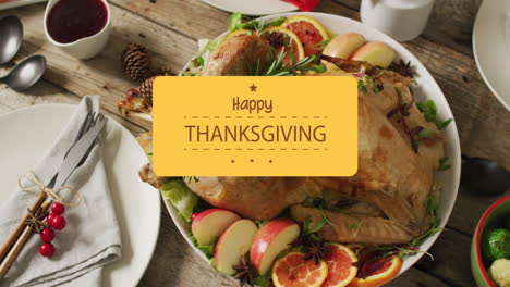 Animation-of-happy-thanksgiving-text-over-cutlery-and-dinner-on-wooden-background