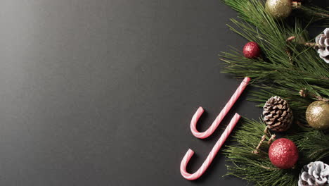 Video-of-baubles-and-candy-canes-christmas-decorations-with-copy-space-on-black-background