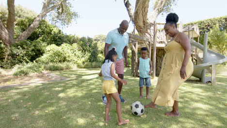 Felices-Abuelos-Afroamericanos-Con-Nietos-Jugando-Al-Fútbol-En-El-Jardín,-En-Cámara-Lenta