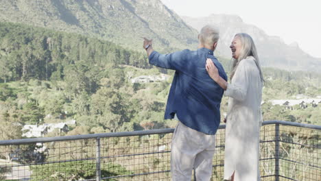 Happy-middle-aged-caucasian-couple-talking-on-terrace-in-mountains,-slow-motion