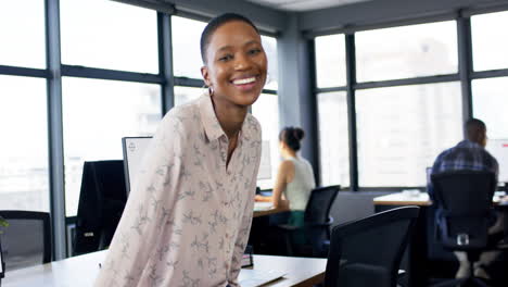 Portrait-of-smiling-african-american-businesswoman-in-office,-slow-motion,-copy-space