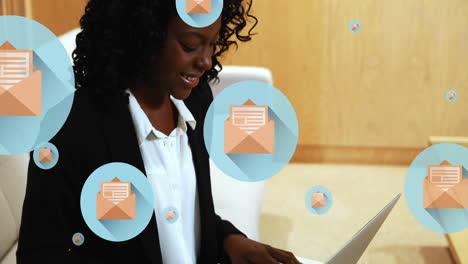 Animation-of-letter-and-envelope-icons-in-circles,-african-american-woman-working-on-laptop