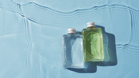 Video-Von-Kosmetikflaschen-Im-Wasser-Mit-Kopierraum-Auf-Blauem-Hintergrund