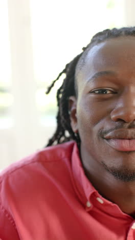 Vertikales-Video-Halbporträt-Eines-Afroamerikanischen-Mannes-Mit-Dreadlocks,-Der-In-Der-Sonne-Lächelt,-Zeitlupe