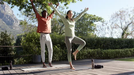 Glückliches,-Vielfältiges-Paar,-Das-Yoga-Im-Sonnigen-Garten-Praktiziert,-Kopienraum,-Zeitlupe