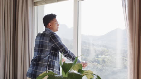 Thoughtful-african-american-man-looking-at-sunny-mountain-view-from-window,-copy-space,-slow-motion