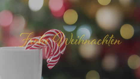 Animation-of-frohe-weihnachten-text-over-candy-canes-in-mug-over-spot-lishts-background