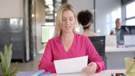 Caucasian-businesswoman-reading-document-in-office-with-copy-space