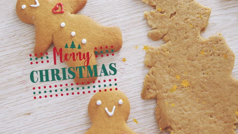 Animation-of-merry-christmas-text-over-snowman-shape-cookies-with-mold-on-wooden-table