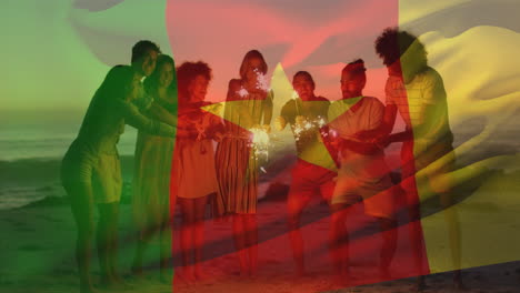 Animación-De-La-Bandera-De-Camerún-Sobre-Diversos-Amigos-Con-Bengalas-Disfrutando-En-La-Playa.