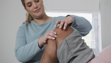 Caucasian-female-physiotherapist-checking-knee-of-senior-woman,-copy-space,-slow-motion