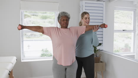 Caucasian-female-physiotherapist-with-senior-woman-exercising,-copy-space,-slow-motion