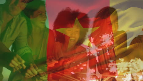 Animation-of-flag-of-cameroon-over-diverse-friends-with-sparklers-enjoying-at-beach
