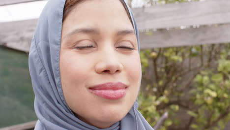 Portrait-of-smiling-biracial-woman-in-hijab-with-copy-space,-slow-motion