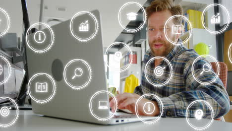 Animation-of-multiple-icon-in-circles-over-caucasian-man-using-cellphone-and-laptop-in-office