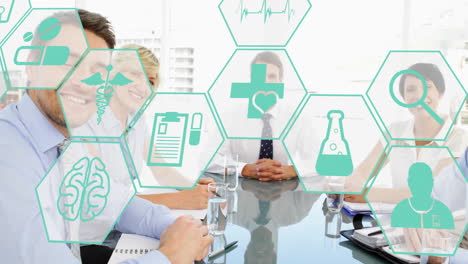Animation-of-medical-icons-in-hexagons-over-caucasian-partners-shaking-hands-in-board-room