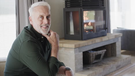 Portrait-of-middle-aged-happy-caucasian-man-sitting-in-living-room-at-home-with-copy-space