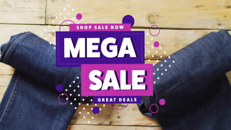 Animation-of-mega-sale-text-over-denim-trousers-on-wooden-background