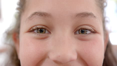 Augen-Eines-Glücklichen-Biracial-Mädchens-Mit-Langen,-Lockigen-Haaren,-Das-In-Einer-Sonnigen-Küche-Steht-Und-Lächelt