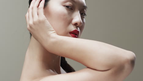 Asian-woman-with-black-hair,-red-lips-and-make-up-toching-her-face,-copy-space,-slow-motion