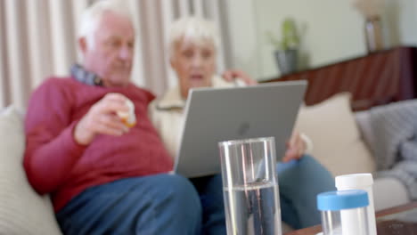 Senior-caucasian-couple-using-laptop-for-online-doctor-consultation-at-home,-slow-motion