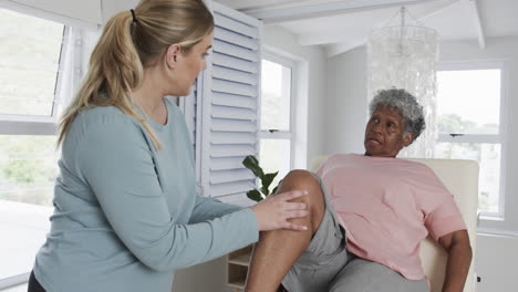 Kaukasische-Physiotherapeutin-überprüft-Das-Knie-Einer-älteren-Frau,-Kopierraum,-Zeitlupe