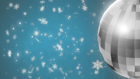 Animation-of-mirror-disco-ball-spinning-over-snow-falling-on-blue-background