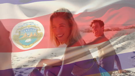 Animation-of-flag-of-costa-rica-waving-over-diverse-friends-sitting-and-enjoying-at-beach