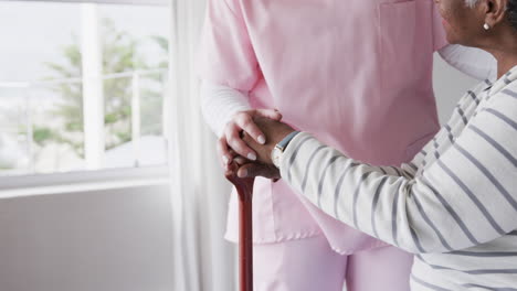 Kaukasische-Krankenschwester-Hält-Hände-Einer-älteren-Afroamerikanischen-Frau,-Kopierraum,-Zeitlupe