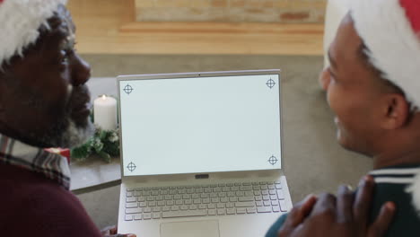 Happy-african-american-father-and-son-having-christmas-laptop-video-call,-copy-space,-slow-motion