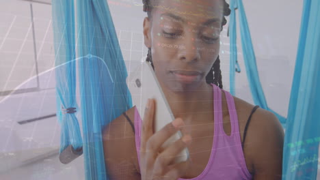 Animation-of-multiple-graphs-and-trading-boards,-african-american-woman-making-call-using-cellphone