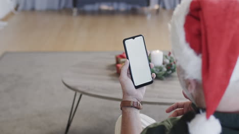 Middle-aged-caucasian-man-using-smartphone-with-blank-screen-at-christmas-at-home,-slow-motion