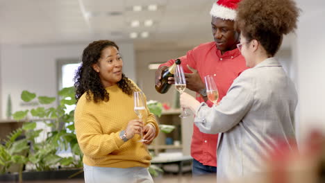 Casual-diverse-businesspeople-drinking-champagne-at-christmas-in-office,-slow-motion
